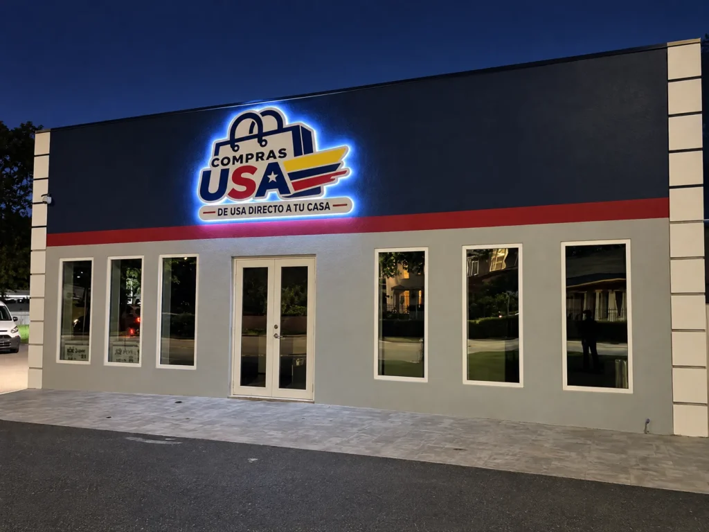 Fachada de una tienda con letrero de logo iluminado de noche